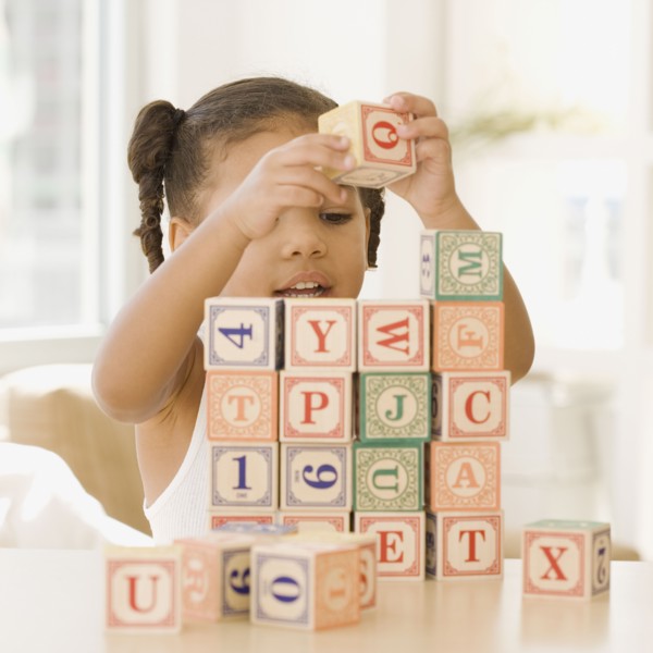 African girl building wall of blocks