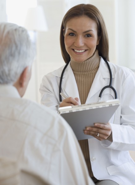 Portrait of Hispanic female doctor writing on chart
