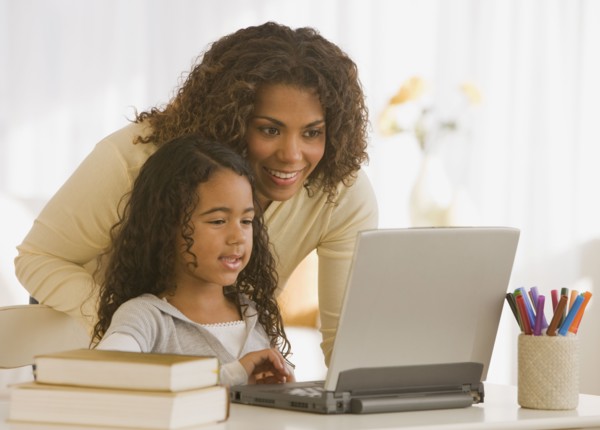 African mother and daughter looking at laptop