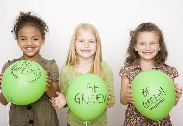 Multi-ethnic girls holding green balloons