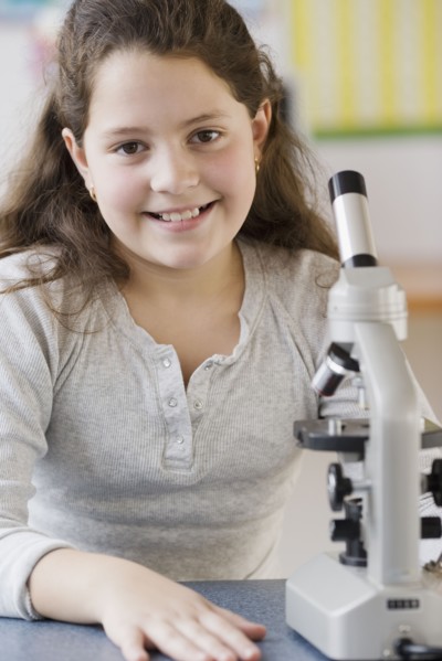 Hispanic girl next to microscope