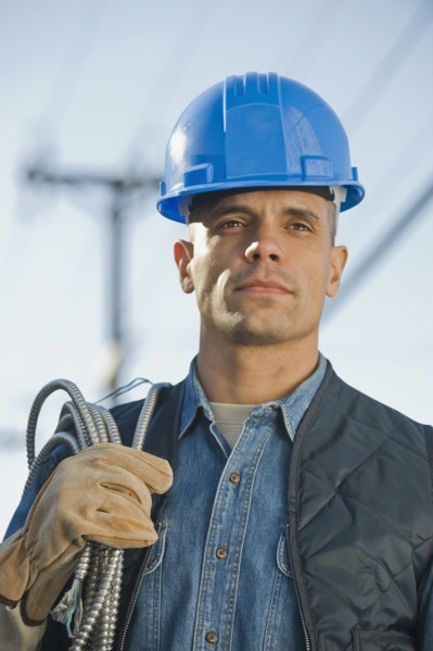 Hispanic male electrician carrying coiled wire