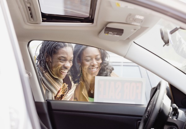 African couple looking at car for sale
