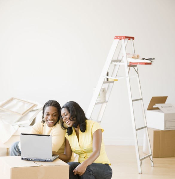 African couple on laptop with moving boxes