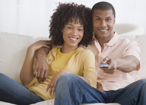 African couple watching television