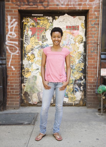 African woman standing near urban doorway