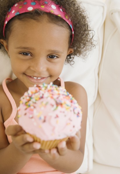 Mixed race girl holding cupcake