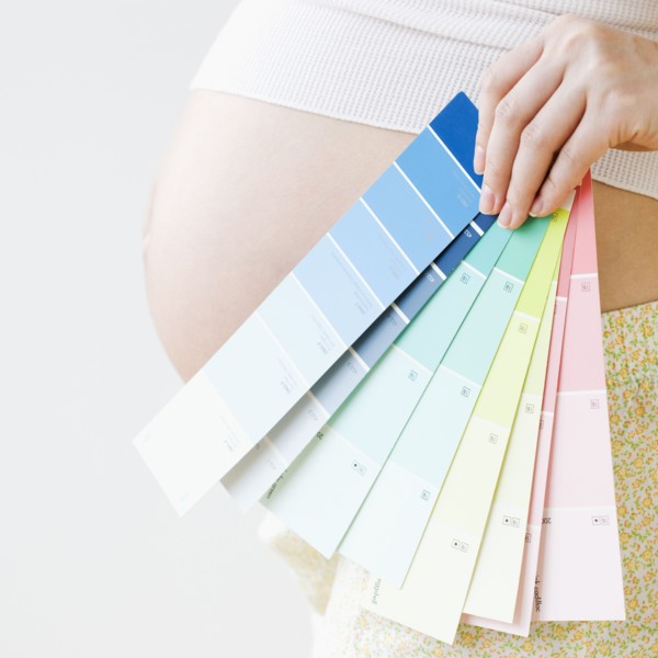 Pregnant Asian woman holding several color swatches