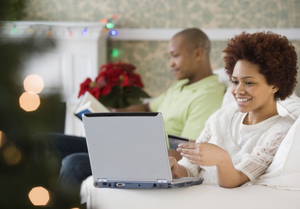 Mixed race woman buying Christmas presents online with credit card
