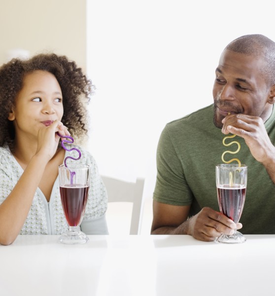 African father and daughter drinking with straws