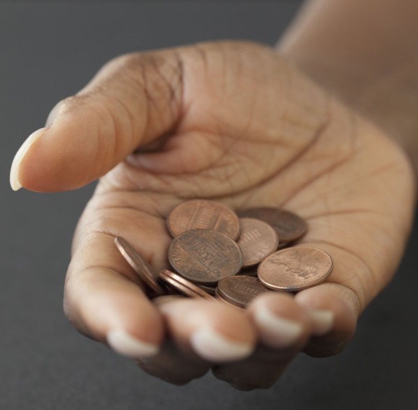 African woman holding handful of pennies