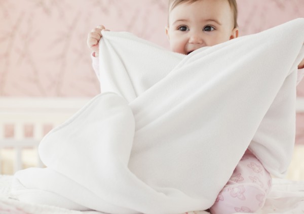 Mixed race baby girl playing with blanket