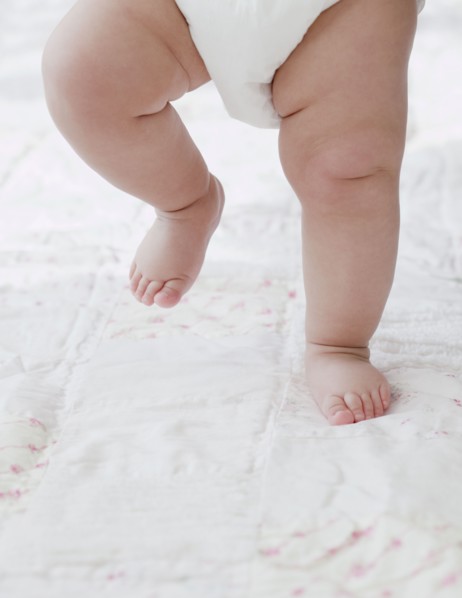 Mixed race baby girl walking on blanket