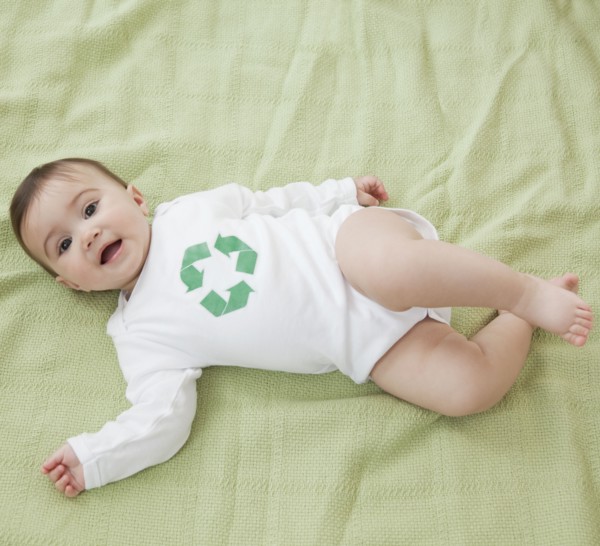 Mixed race baby girl with recycling symbol on shirt