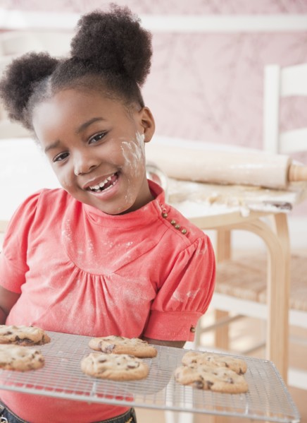 African girl holding fresh baked cookies