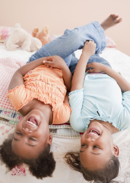 African girls laughing on bed