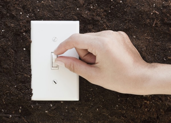 Woman flipping light switch in soil