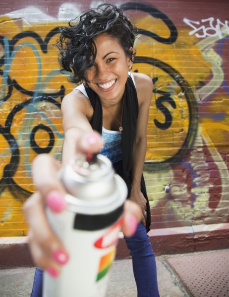 Mixed race graffiti artist holding spray paint can