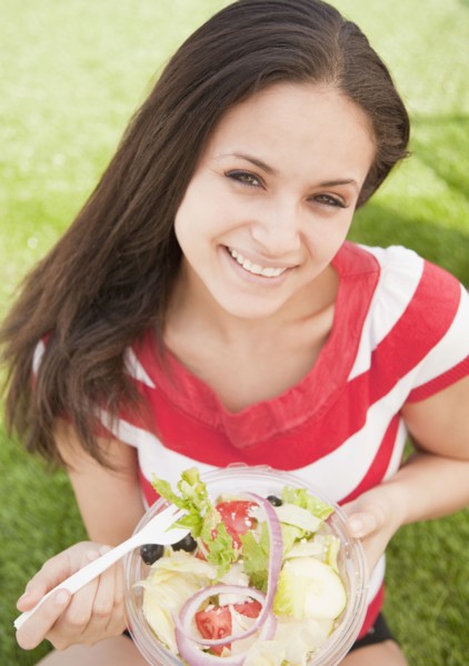 Mixed race woman eating salad