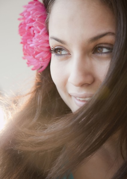Mixed race woman with flower in hear