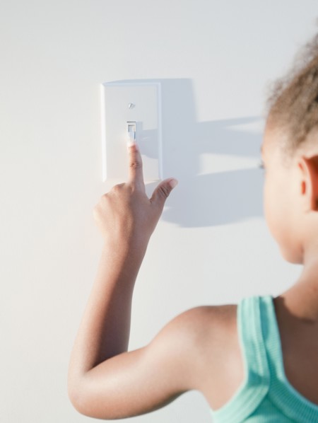 Mixed race girl turning off light