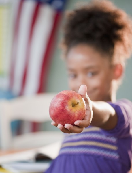 Mixed race girl holding apple