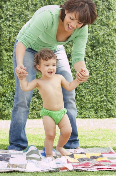 Hispanic mother helping daughter learn to walk