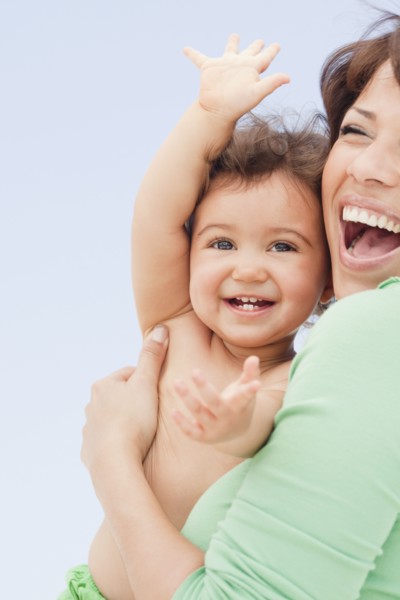 Laughing Hispanic woman holding daughter