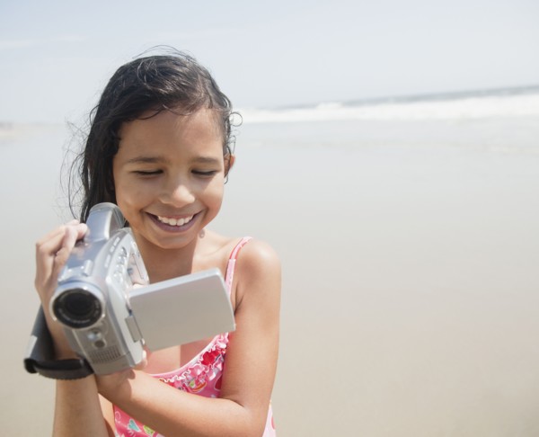 Hispanic girl using video camera