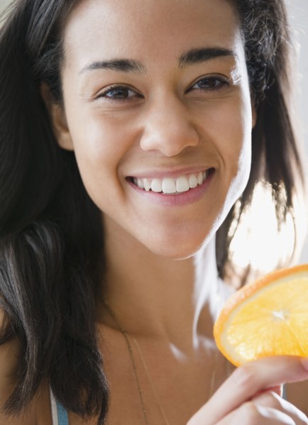 Mixed race woman holding orange slice