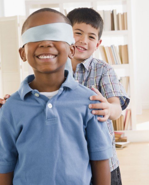 Boy spinning friend wearing blindfold