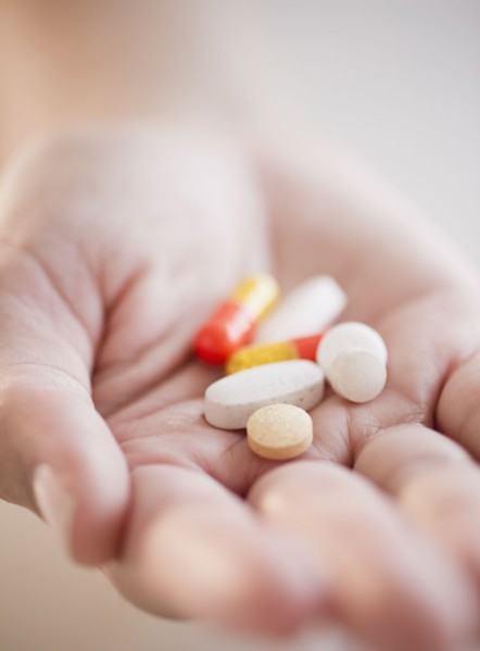 Hand holding pills and capsules