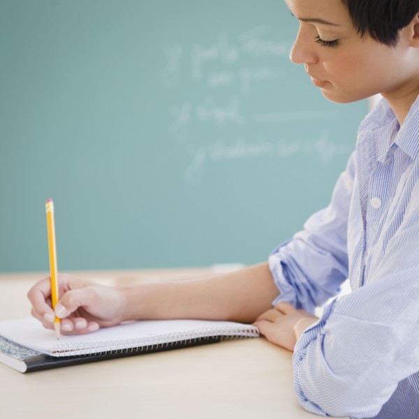 Mixed race woman writing in notebook