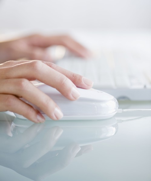 Hands operating computer mouse and keyboard