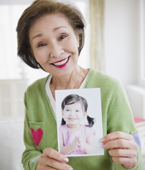 Japanese woman holding photograph of girl