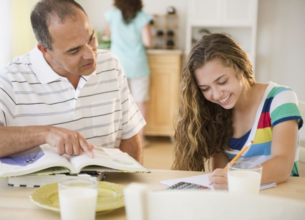 Hispanic father helping daughter with homework