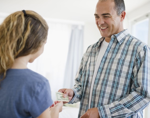 Hispanic father handing daughter money
