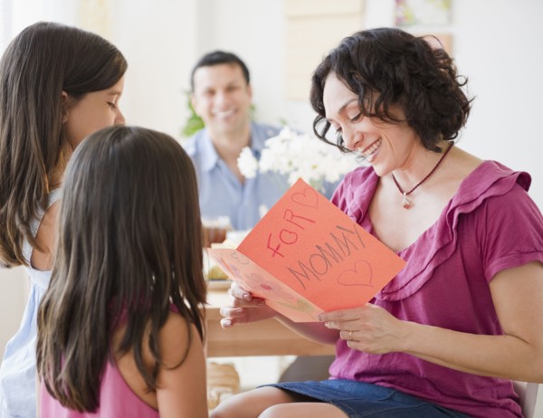 Daughters giving mother Mother's Day card