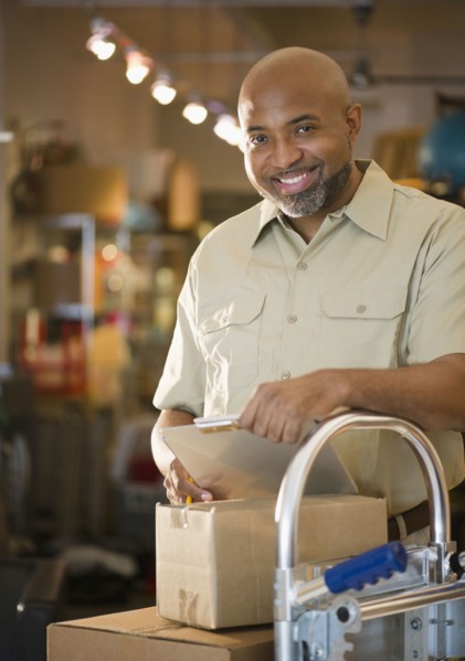 African American deliveryman with clipboard and boxes