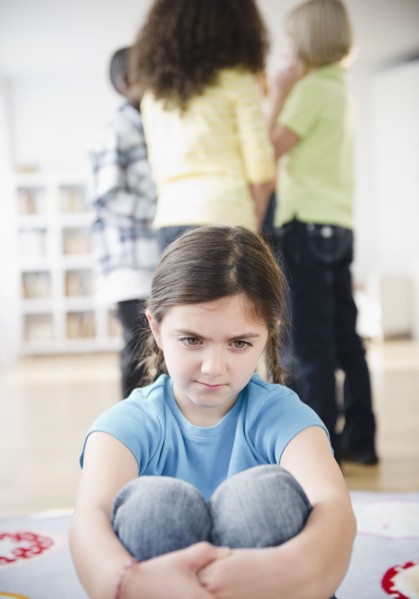 Lonely girl ignoring friends playing