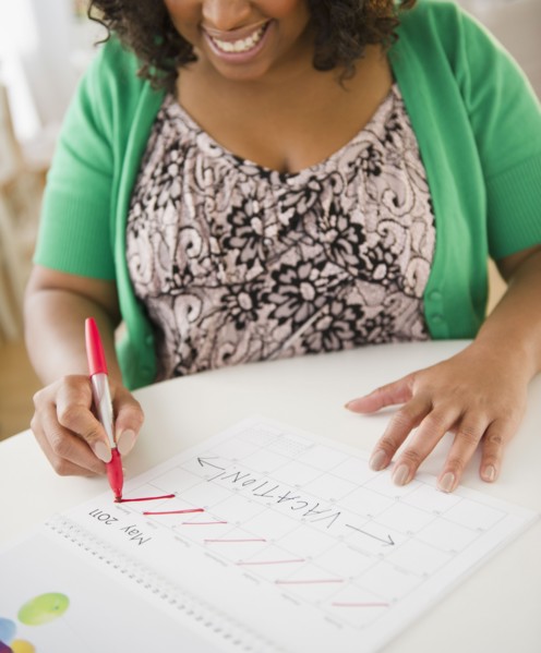 African American woman crossing off days on calendar