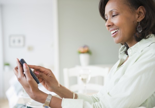 Black woman text messaging on cell phone