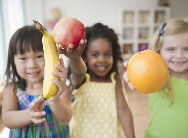 Children holding out fresh fruit