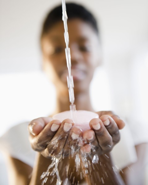 Water splashing on soap in Black woman's hands