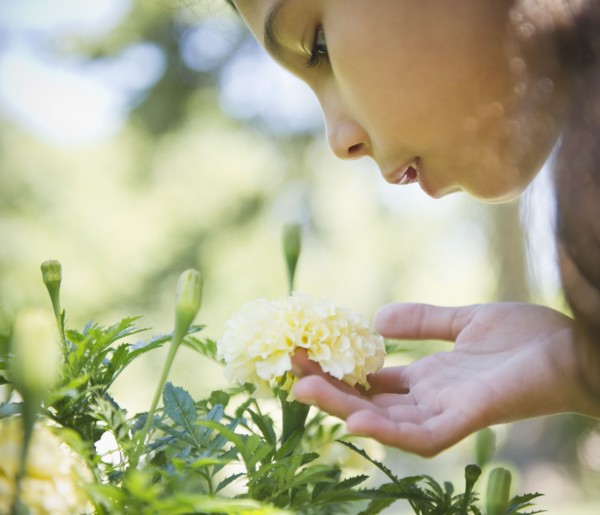 Hispanic girl smelling flower
