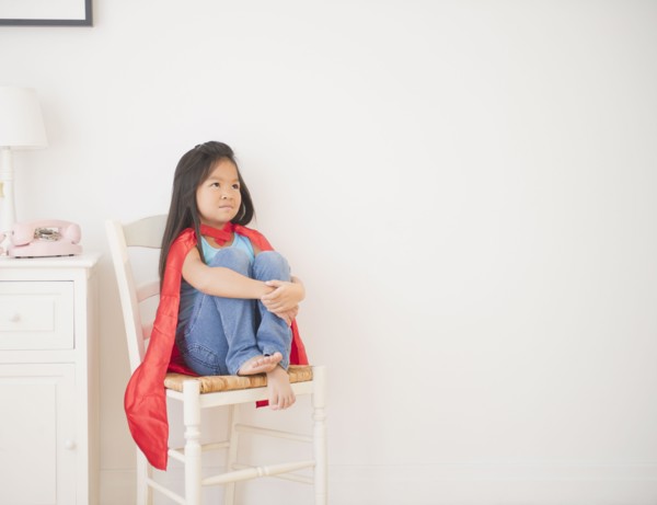 Korean girl in cape sitting on chair