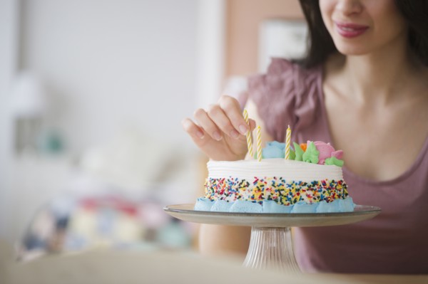 Mixed race woman preparing birthday cake