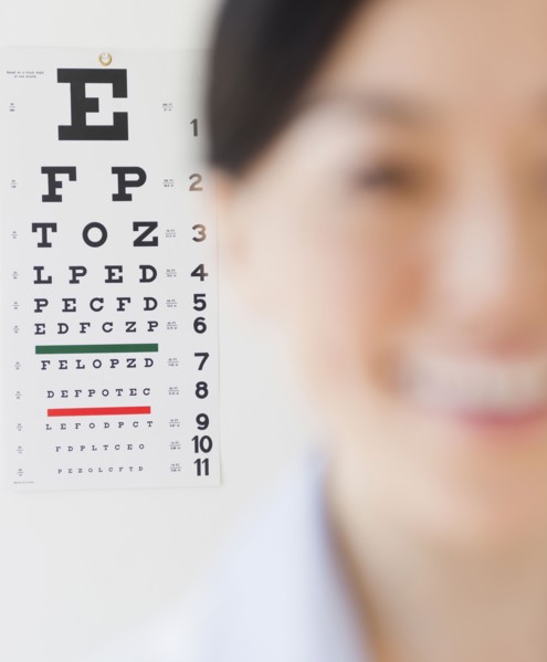 Japanese optometrist in front of eye chart