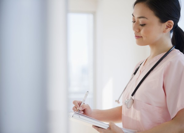 Japanese nurse writing on medical record