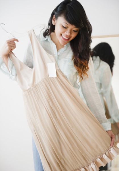 Pacific Islander woman looking at dress in store